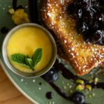 A plate with a piece of bread and blueberries on it
