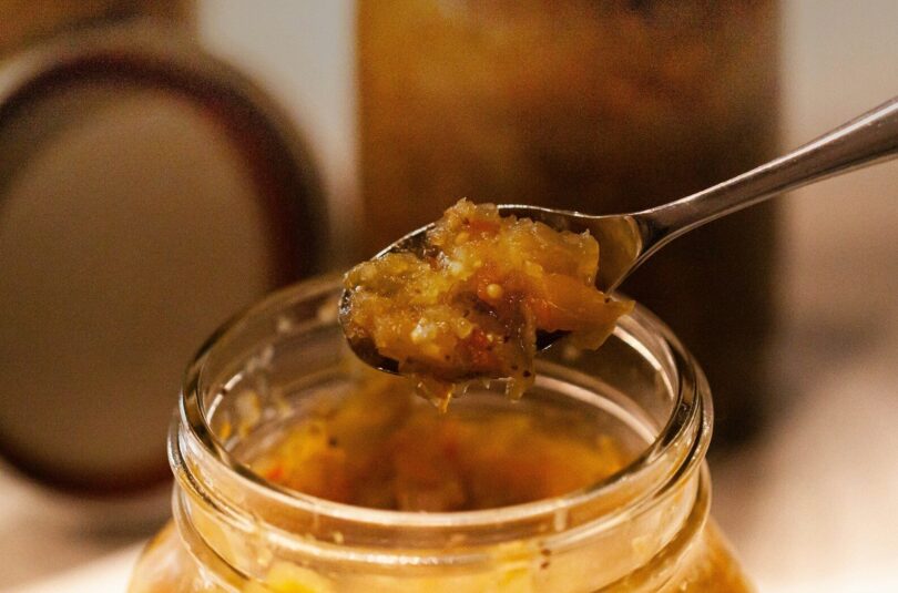 a spoon full of food sitting on top of a jar