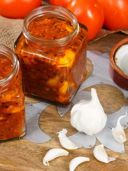 a wooden cutting board topped with jars of food