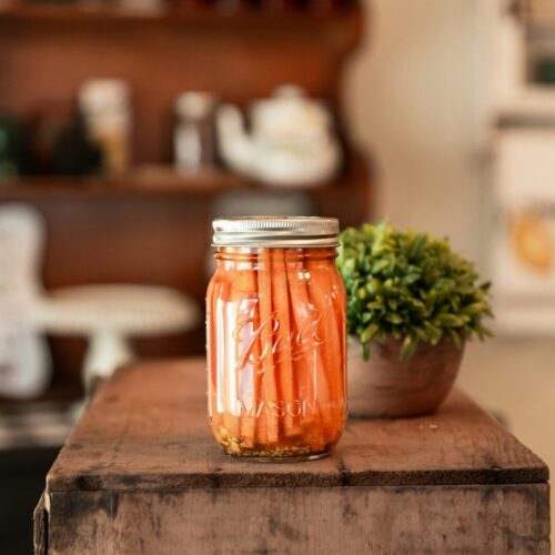 rhwnvfxz0hg a jar of pickled carrots sitting on a table
