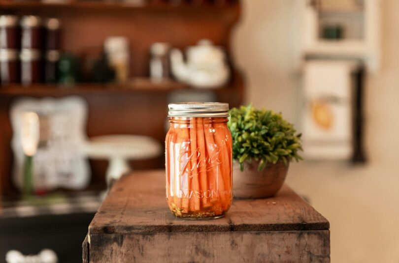 a jar of pickled carrots sitting on a table